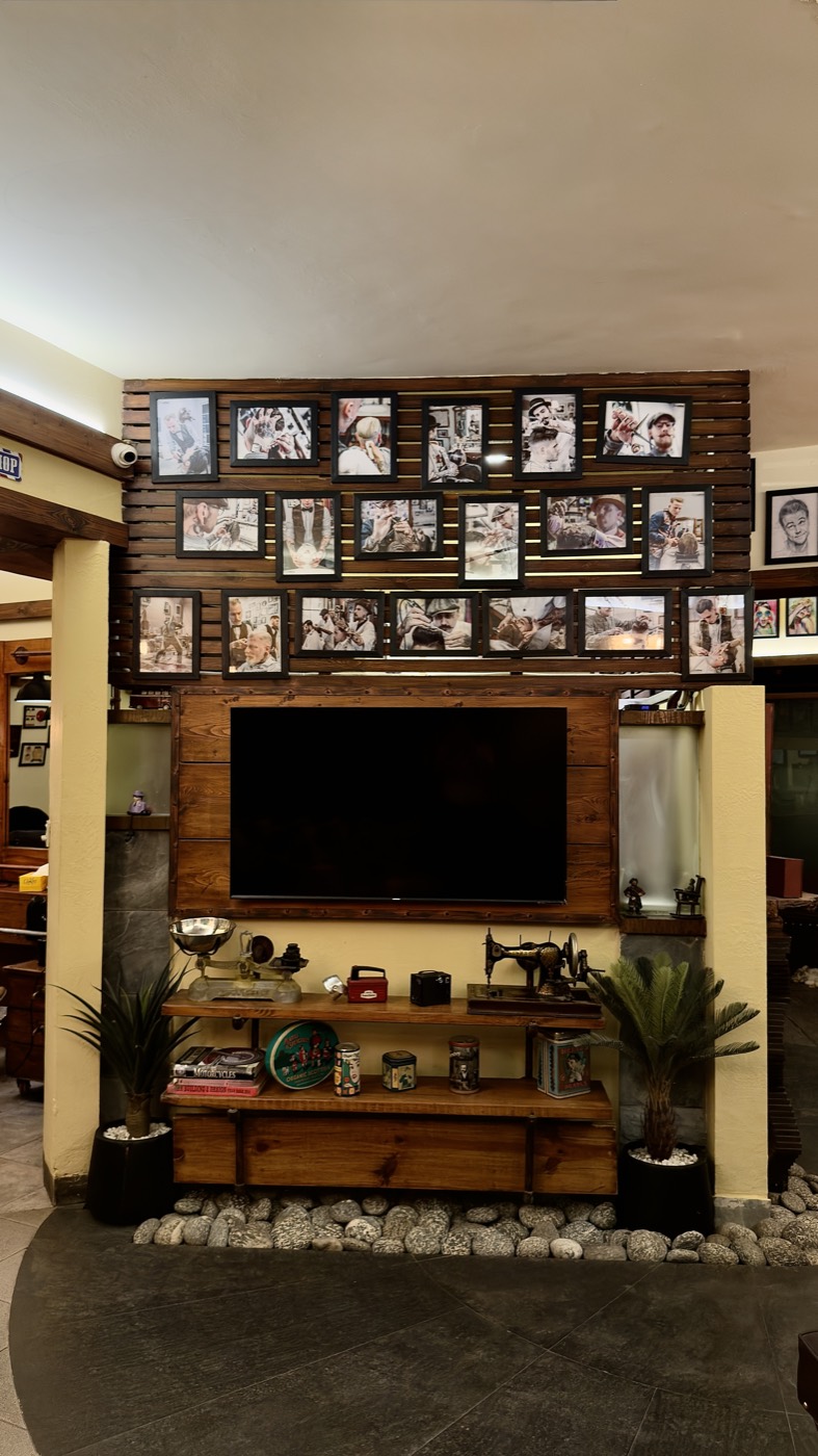 A wall of framed photographs around a screen at the Zamzama branch
